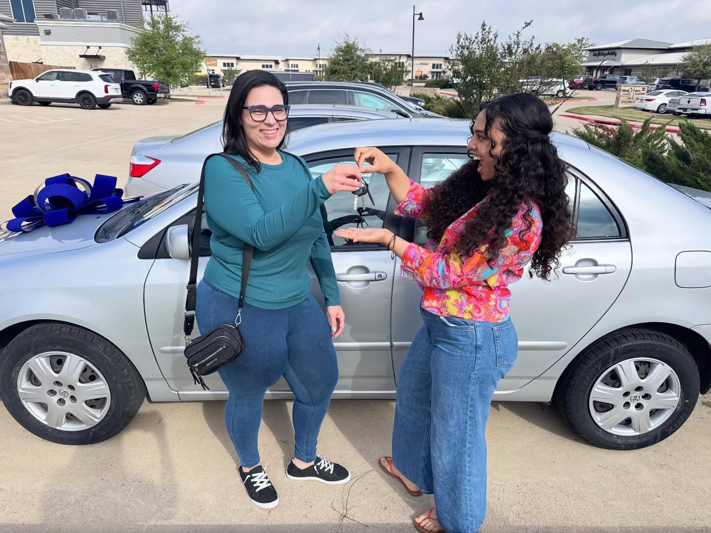 Client receiving donated vehicle with gift bow