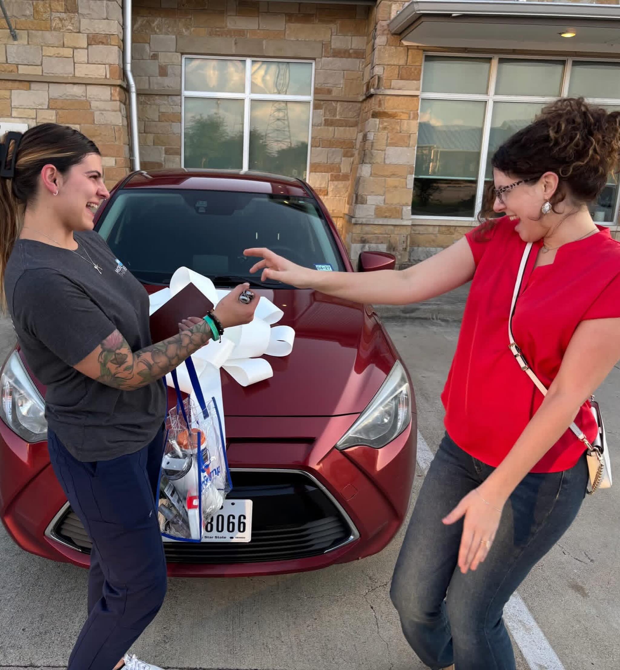 Client receiving keys to donated vehicle, laughing with joy